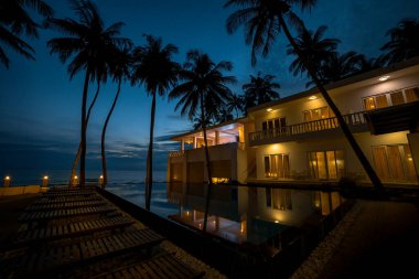 Açık mavi havuz ve Vietnam 'da gece vakti bir tatil köyünün avlusu.