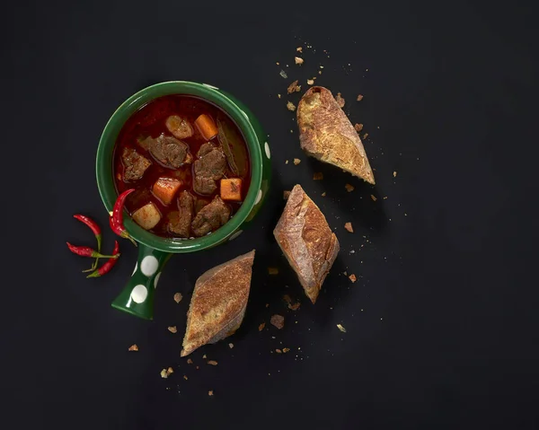 Hjärtlig Gulasch Soppa Med Bröd Och Chili Över Svart Trä — Stockfoto