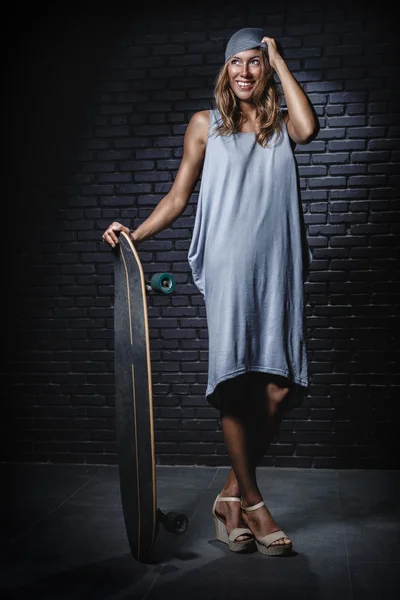 Skateboarder woman in dress — Stock Photo, Image
