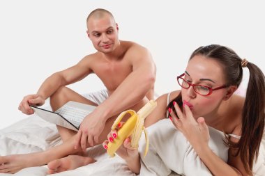 Woman with banana and her boyfriend with laptop clipart