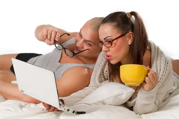 Pareja acostada en la cama viendo en el portátil —  Fotos de Stock