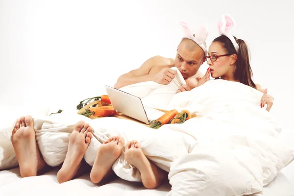 Casal em trajes de coelho assistindo laptop — Fotografia de Stock