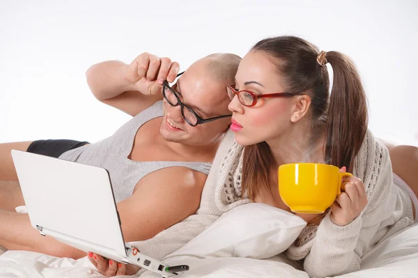 Par liggande på sängen tittar på laptop — Stockfoto