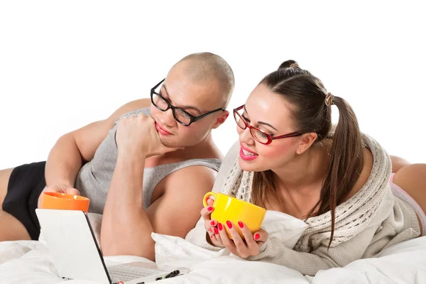 Pareja acostada en la cama viendo en el portátil —  Fotos de Stock