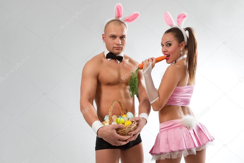 Couple in rabbit costumes with carrot and eggs