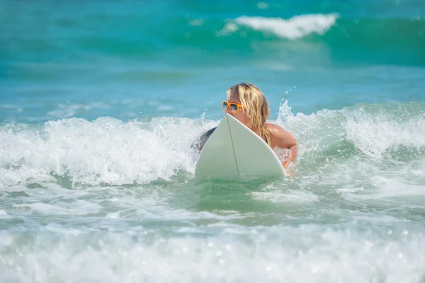 Femme surfeuse sur sa planche de surf dans l'eau — Photo