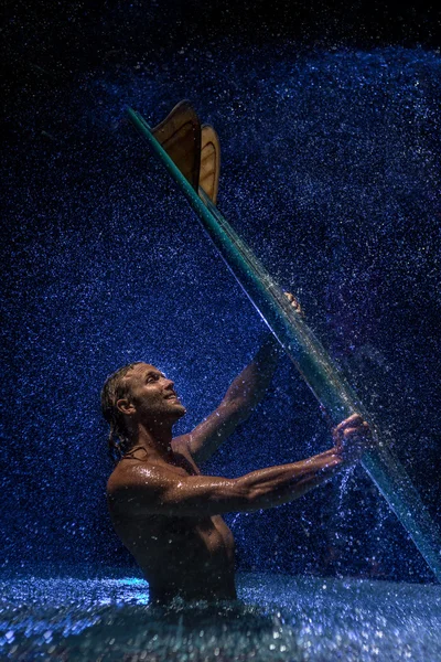 Hombre muscular y tabla de surf en el agua — Foto de Stock