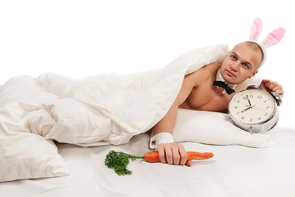 Homem coelho na cama com alarme — Fotografia de Stock