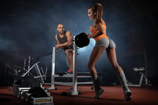 Trainer helping girl  in gym — Stock Photo, Image