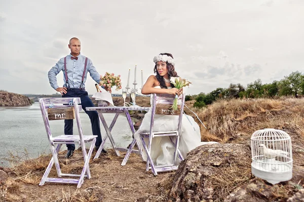 Bride and groom next to table — Stock Photo, Image