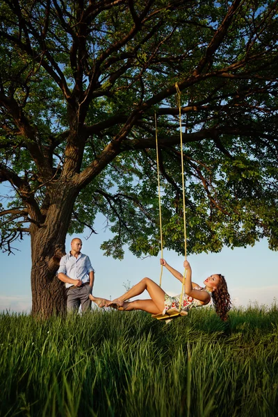 Belle fille sur swing avec petit ami — Photo