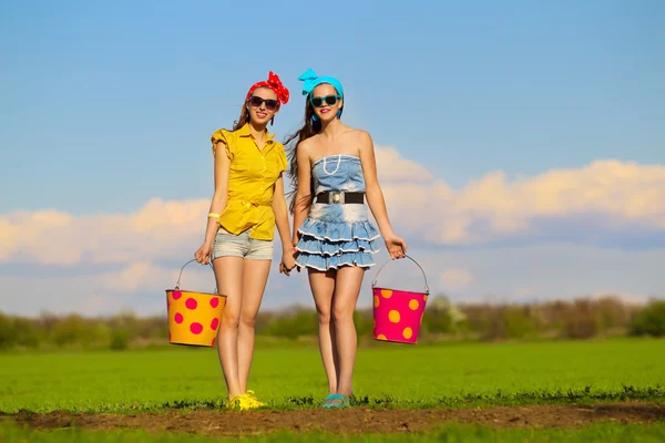 Ragazze con secchi in giardino — Foto Stock