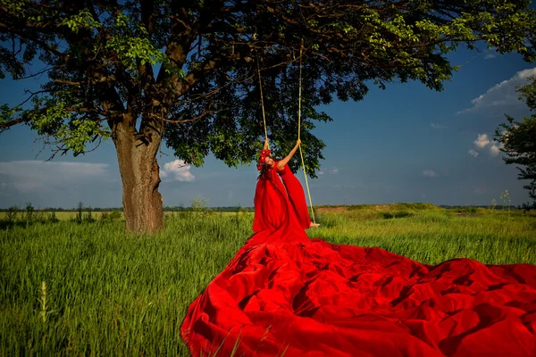 Donna in rosso sull'altalena — Foto Stock