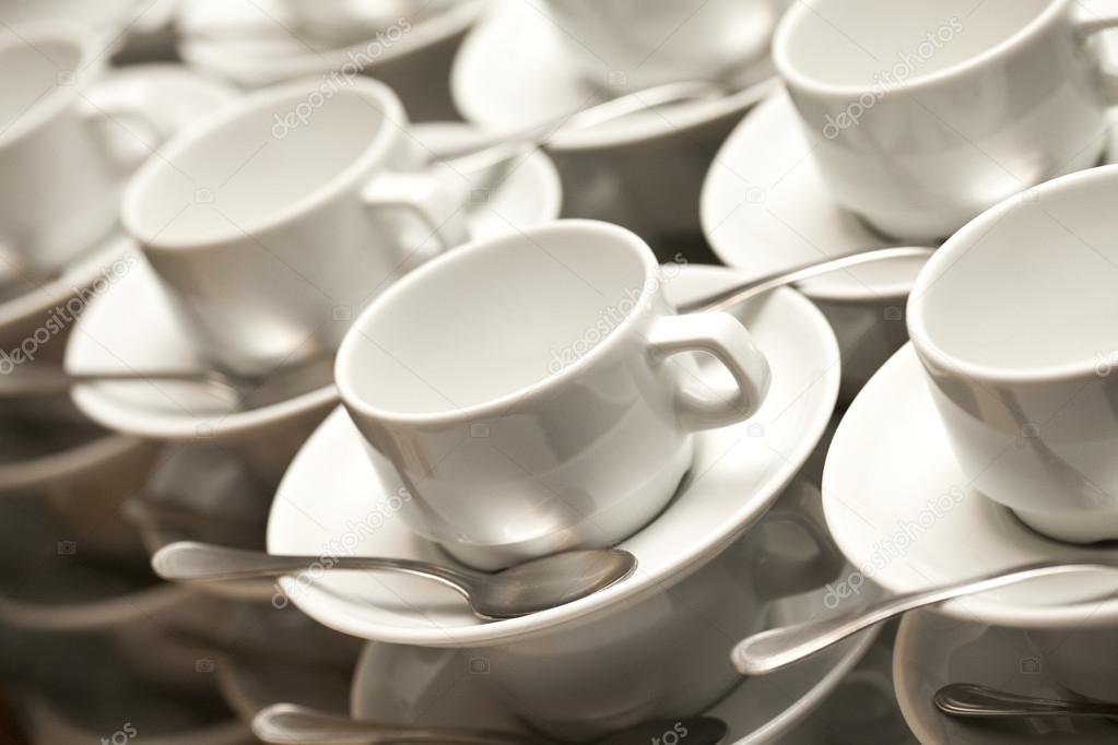 Stacked empty teacups with teaspoons 