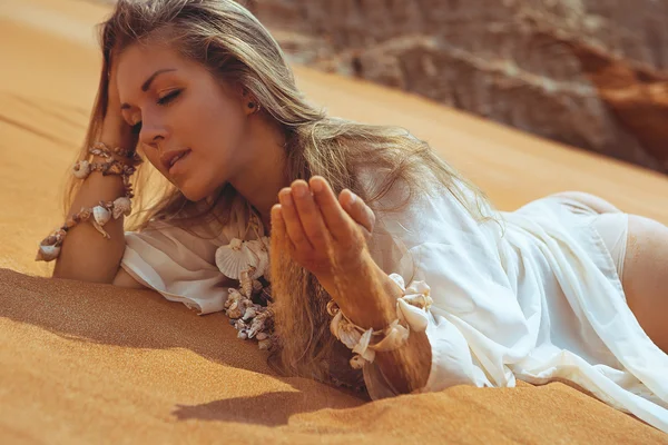 Giovane donna sdraiata sulla spiaggia di sabbia — Foto Stock