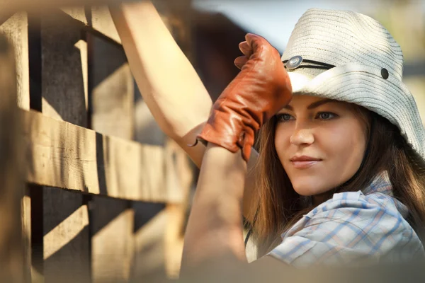 Cowgirl in stetson vicino alla recinzione di legno — Foto Stock