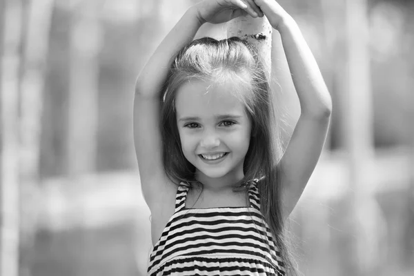 Pequena menina sorridente em vestido listrado — Fotografia de Stock