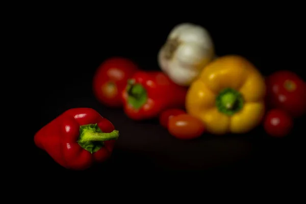 Pepper and other vegetable on black background