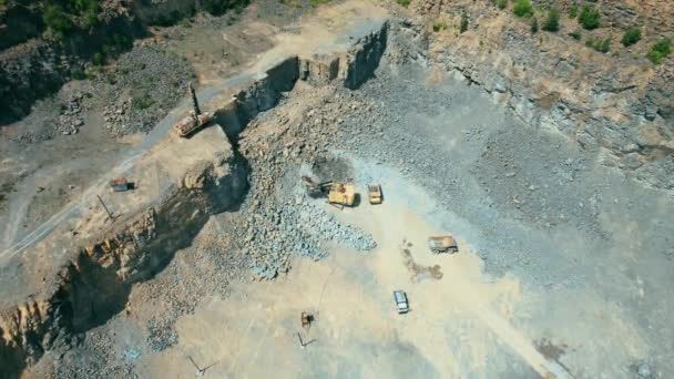 Arieel zicht op de zandmakerij in de open mijnbouw. Drone vliegt over graafmachines en trekker laden geplette steen en steen in dump truck. 4k voorraad beeldmateriaal. — Stockvideo