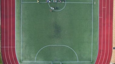 Futbolcularla futbol sahasının insansız hava görüntüsü. 4k stok görüntüsü.