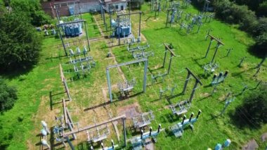 Transformatörler, elektrik kuleleri ve elektrik hatları bir elektrik santralinin zeminini kapatıyor. 4k stok görüntüsü.