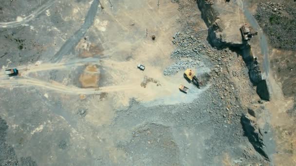 Arieel zicht op de zandmakerij in de open mijnbouw. Drone vliegt over graafmachines en trekker laden geplette steen en steen in dump truck. 4k voorraad beeldmateriaal. — Stockvideo