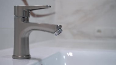 Erkek el banyoda su doldurmak için musluğu küvete dolduruyor. 4k stok görüntüsü.