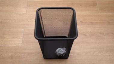 Yavaş çekim buruşmuş kağıt top çöp kutusuna düşüyor. 4k stok görüntüsü.