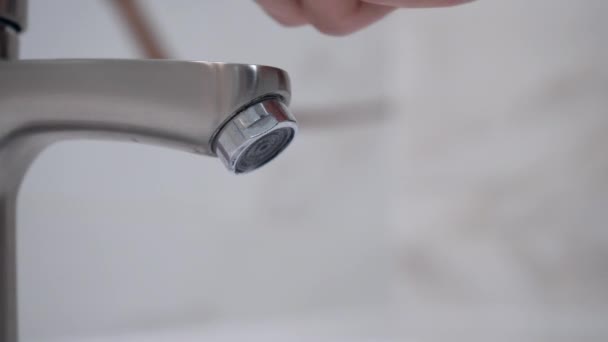 Mâle main tournant robinet d'eau pour verser de l'eau dans la baignoire dans la salle de bain. Images du stock 4k. — Video