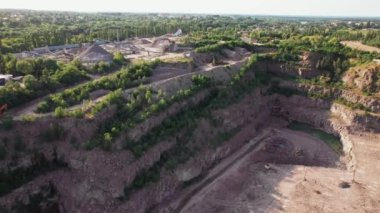 Açık çukur madenciliğindeki kum fabrikasının Arial görüntüsü. Drone kazıcıların üzerinden uçuyor ve traktör ezilmiş taşı ve kayayı çöp kamyonuna yüklüyor. 4k stok görüntüsü.