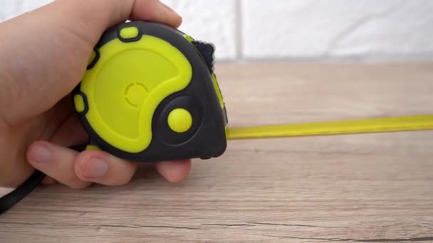 Measuring with yellow tape measure. Hands pull the measuring tape out of tape measure and measure the length. 4k stock footage. — Stock Video