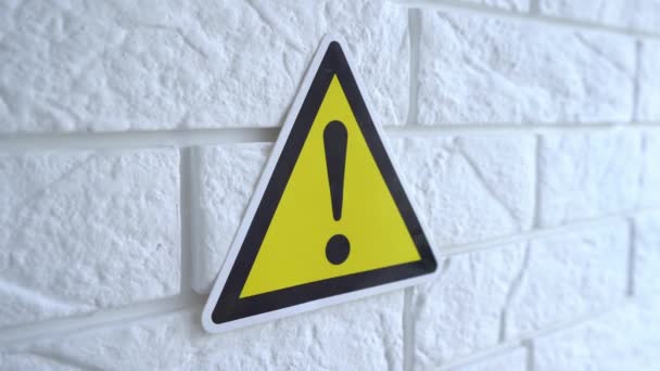 Électricité danger un signe sur fond jaune. Un panneau de danger pend sur un mur. Images du stock 4k. — Video