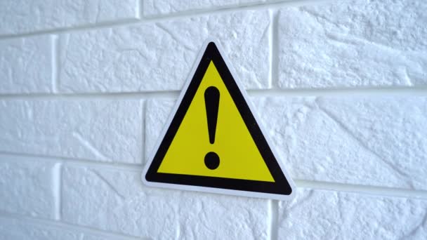 Électricité danger un signe sur fond jaune. Un panneau de danger pend sur un mur. Images du stock 4k. — Video