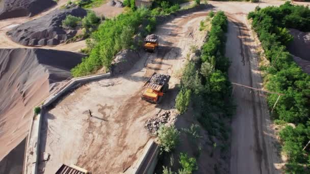 Vista Arial da fábrica de areia em mineração a céu aberto. O drone voa sobre escavadoras e trator carregando pedras e rochas esmagadas em caminhões basculantes. Imagens de estoque 4k. — Vídeo de Stock