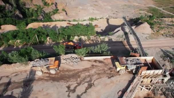 Vue ariale de l'usine de fabrication de sable dans l'exploitation minière à ciel ouvert. Drone vole sur les pelles et tracteur chargement de pierre concassée et de roche dans le camion à benne. Images du stock 4k. — Video