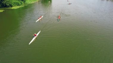 Nehirde Kano yapan insanlar. Kano ve Kano sporları eğitimi merkezi. 4K hava görüntüsü. Yazın nehirde üç kano..