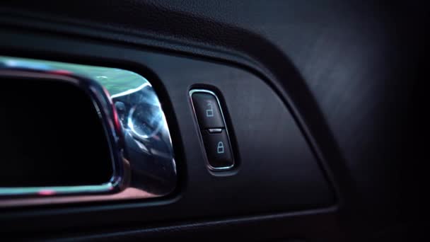 En el reposabrazos la mano presiona los botones para el mecanismo eléctrico de elevación de las ventanas en la puerta del coche. Imágenes de vídeo 4K. — Vídeo de stock