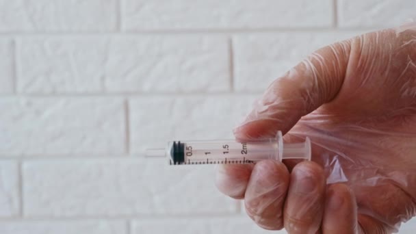 Spuit naaldprikken. De injectienaald doorboort de rubberen stop van de glazen injectieflacon. 4K-videobeelden. — Stockvideo