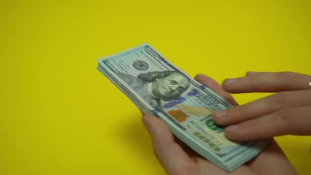 El dinero cae sobre la mesa. Manos de hombre Considere billetes de dólar en una mesa de madera. Imágenes de vídeo 4K. — Vídeo de stock