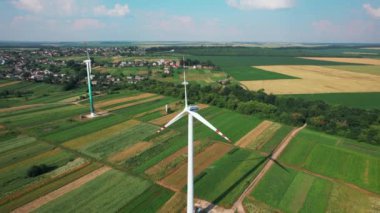 Rüzgarın gücüyle dönen rüzgar değirmenlerinin hava görüntüsü ve yenilenebilir enerji üretimi. 4K video görüntüleri.