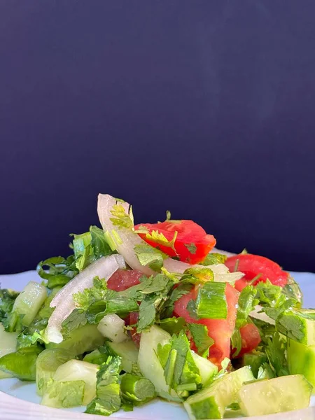 Macro shot of a salad with fresh vegetables and herbs. Freshly made Mediterranean salad on plate.