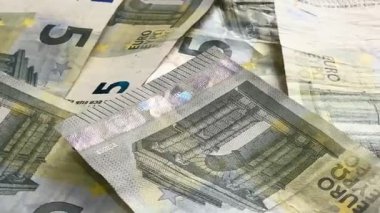 Macro shots of swirling euros highlight financial themes such as pensions, taxes, income, and losses. Money, economics, and financial literacy.