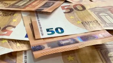 Macro shots of swirling euros highlight financial themes such as pensions, taxes, income, and losses. Money, economics, and financial literacy.