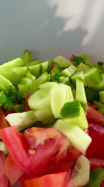Macro shot of a salad with fresh vegetables and herbs. Freshly made Mediterranean salad on plate. 