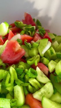 Macro shot of a salad with fresh vegetables and herbs. Freshly made Mediterranean salad on plate. 