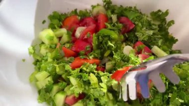 Macro shot of a salad with fresh vegetables and herbs. Freshly made Mediterranean salad on plate.