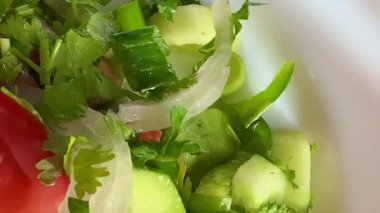 Macro shot of a salad with fresh vegetables and herbs. Freshly made Mediterranean salad on plate.
