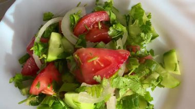Macro shot of a salad with fresh vegetables and herbs. Freshly made Mediterranean salad on plate.