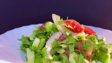 Macro shot of a salad with fresh vegetables and herbs. Freshly made Mediterranean salad on plate.