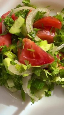 Macro shot of a salad with fresh vegetables and herbs. Freshly made Mediterranean salad on plate.